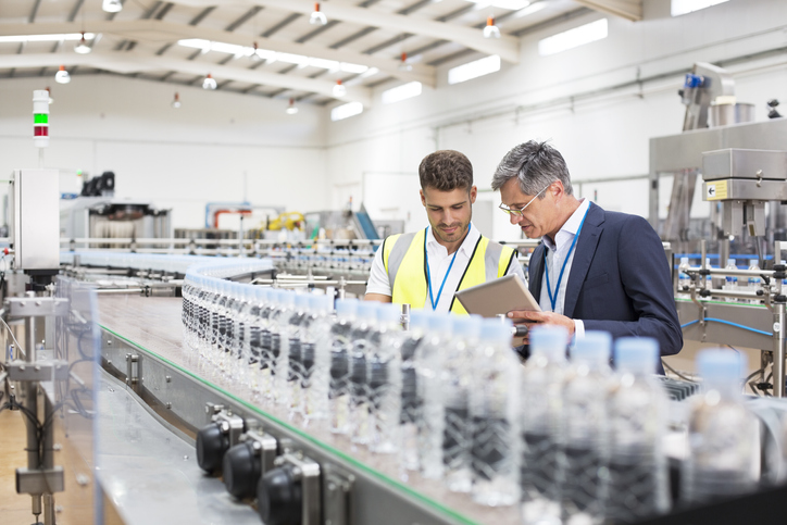 Workers looking at a clipboard in a manufacturing plant